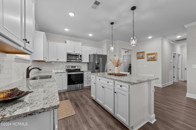 kitchen featuring a kitchen island, stainless steel appliances, sink, white cabinets, and dark hardwood / wood-style flooring