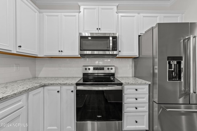 kitchen with appliances with stainless steel finishes, white cabinetry, and ornamental molding