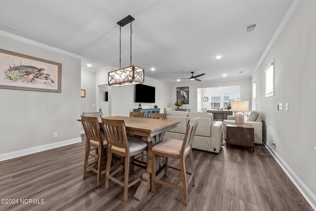 dining space with ornamental molding, dark wood-type flooring, and ceiling fan