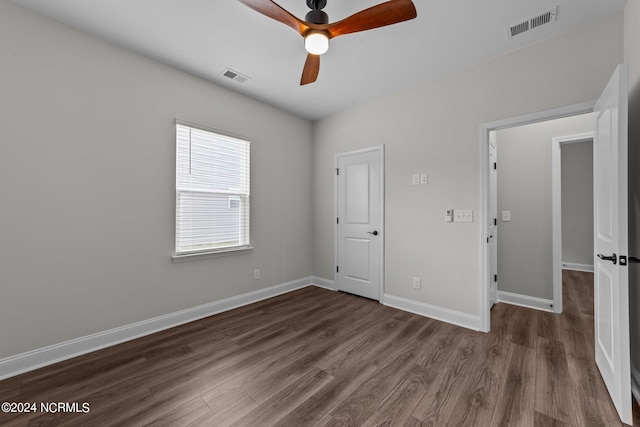 unfurnished bedroom featuring dark hardwood / wood-style floors and ceiling fan