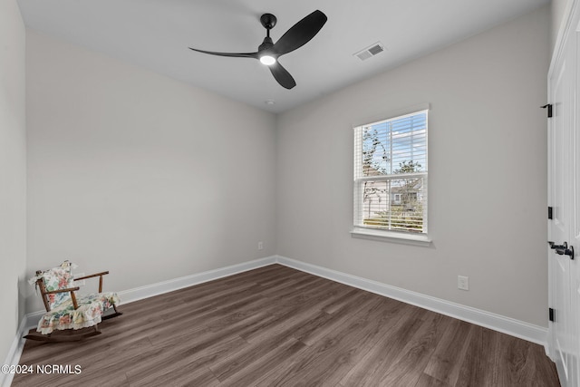 empty room with ceiling fan and dark hardwood / wood-style flooring