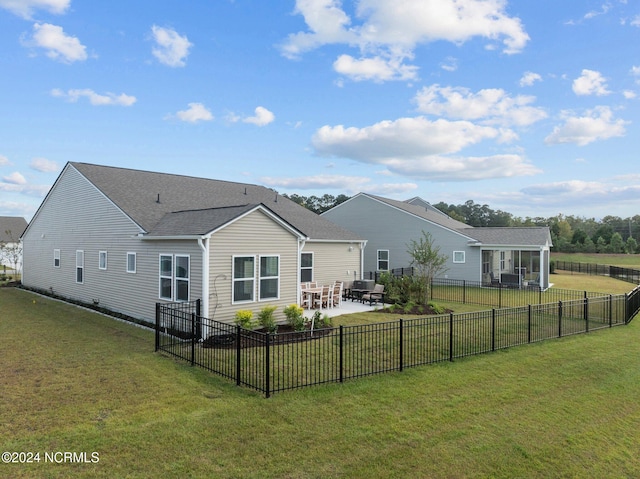 back of property with a yard and a patio