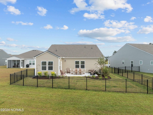 back of property with a yard, a patio area, and a sunroom