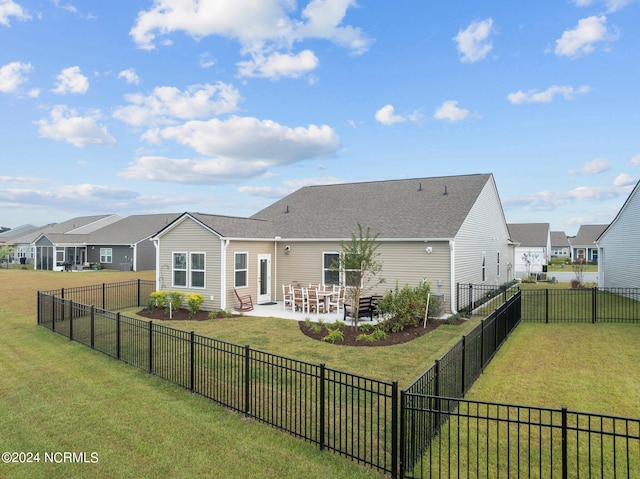 back of house featuring a patio area and a lawn