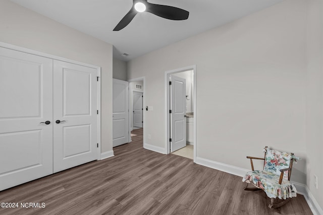 unfurnished bedroom featuring light hardwood / wood-style flooring, a closet, connected bathroom, and ceiling fan