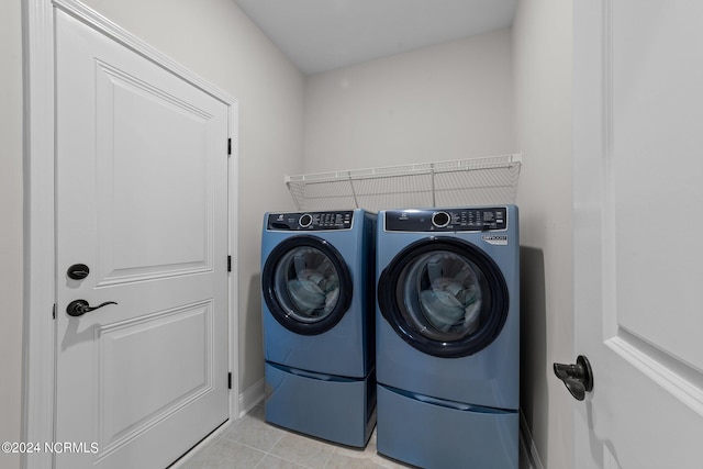 laundry area featuring washing machine and dryer and light tile patterned floors