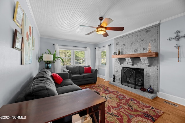 living room with wood-type flooring, a fireplace, and crown molding