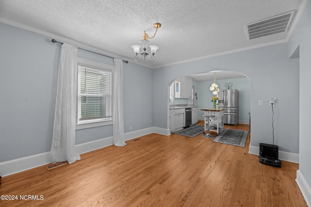 unfurnished dining area with a notable chandelier, a textured ceiling, crown molding, and light hardwood / wood-style floors