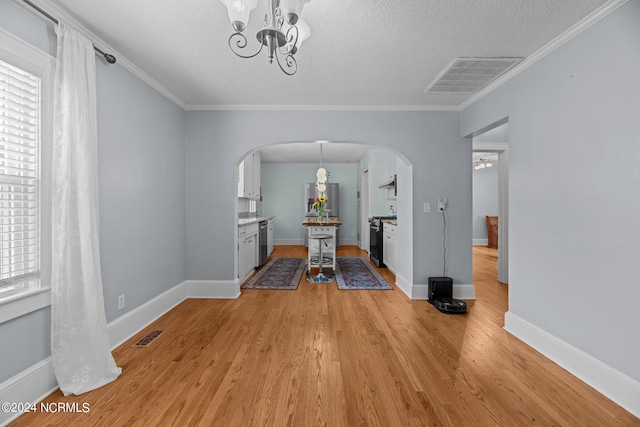 unfurnished dining area with a textured ceiling, crown molding, light hardwood / wood-style floors, and an inviting chandelier