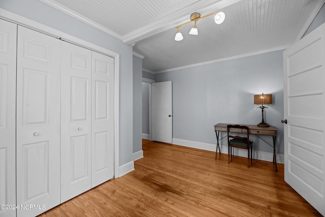 unfurnished bedroom with a closet, hardwood / wood-style floors, and ornamental molding