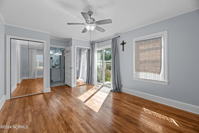 unfurnished bedroom featuring access to outside, hardwood / wood-style floors, ceiling fan, and ensuite bath