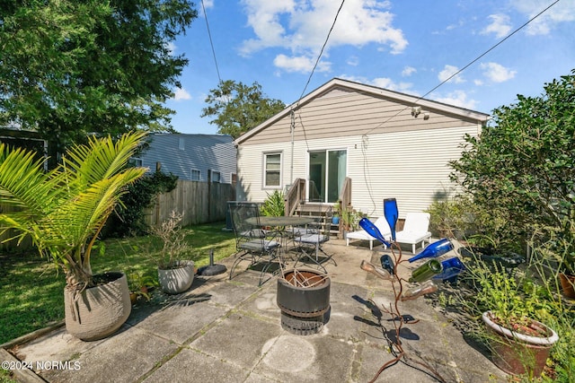 rear view of property with a fire pit and a patio area