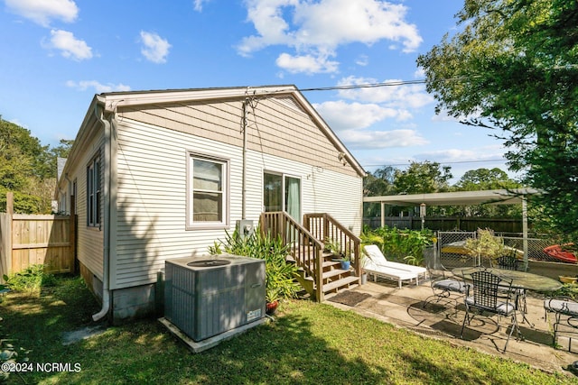 rear view of property with central AC unit, a lawn, and a patio