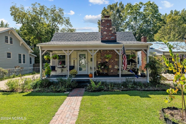 bungalow-style home featuring covered porch and a front yard