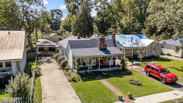 view of front facade featuring covered porch, a front yard, and a carport