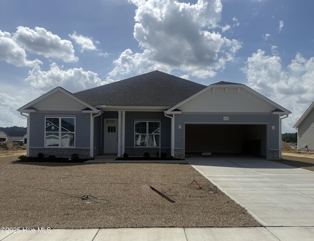 ranch-style home featuring an attached garage, roof with shingles, driveway, and stone siding