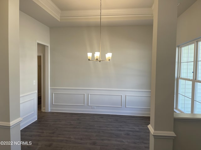 unfurnished dining area featuring ornamental molding, an inviting chandelier, dark hardwood / wood-style flooring, and a tray ceiling