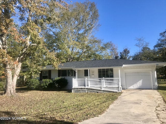 ranch-style house featuring a garage, a front lawn, and covered porch