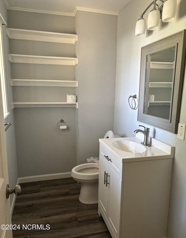 bathroom with hardwood / wood-style flooring, crown molding, vanity, and toilet