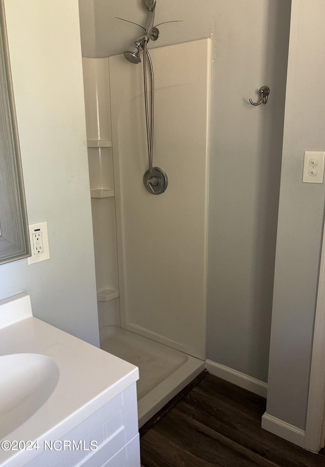 bathroom with vanity, a shower, and hardwood / wood-style flooring