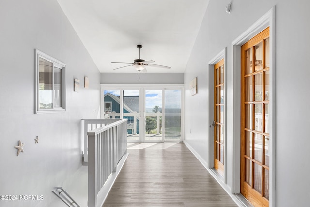 hallway with french doors, hardwood / wood-style floors, and vaulted ceiling