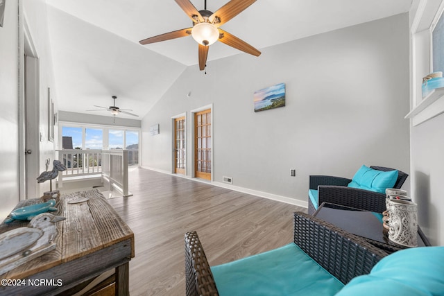 living room featuring lofted ceiling, ceiling fan, and light hardwood / wood-style floors