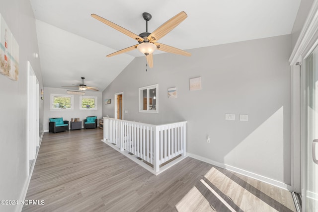 staircase featuring wood-type flooring, vaulted ceiling, and ceiling fan