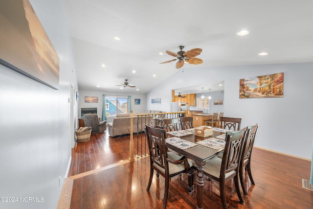 dining room with ceiling fan, dark hardwood / wood-style floors, and vaulted ceiling