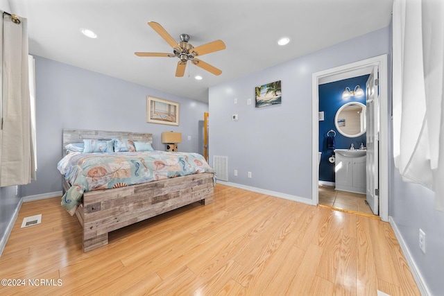 bedroom featuring ensuite bathroom, ceiling fan, sink, and light hardwood / wood-style floors