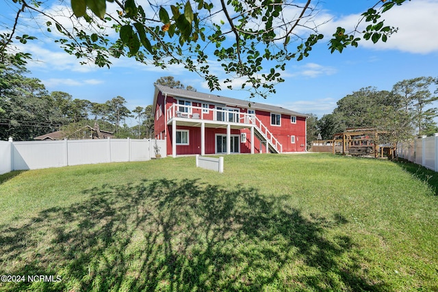 rear view of property with a lawn and a wooden deck