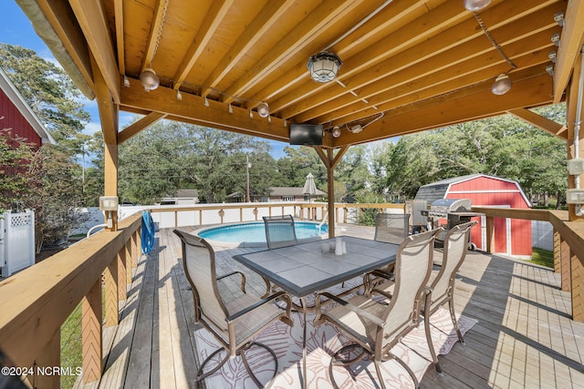 deck with a fenced in pool and a storage shed