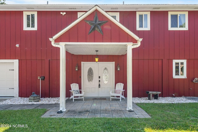 view of exterior entry with a lawn