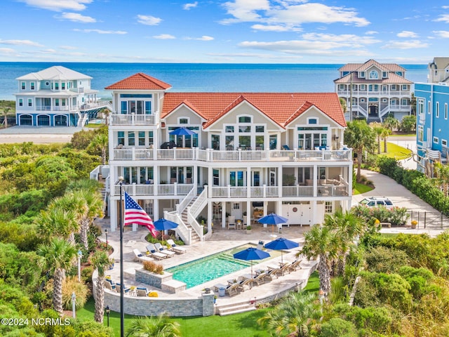 back of house with a balcony, a patio, and a water view