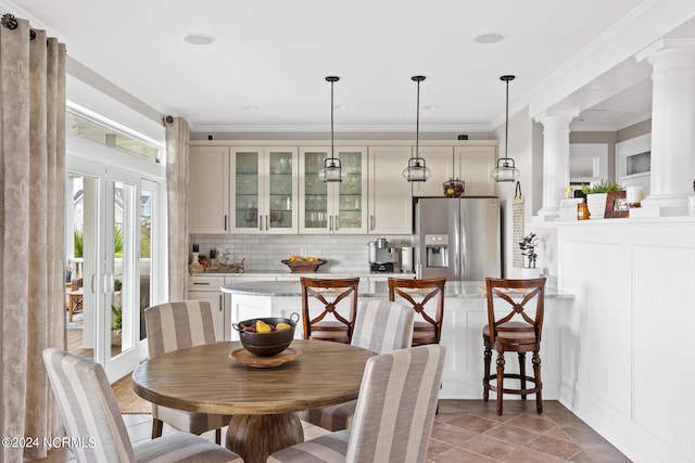 dining room featuring ornamental molding, decorative columns, and tile patterned floors