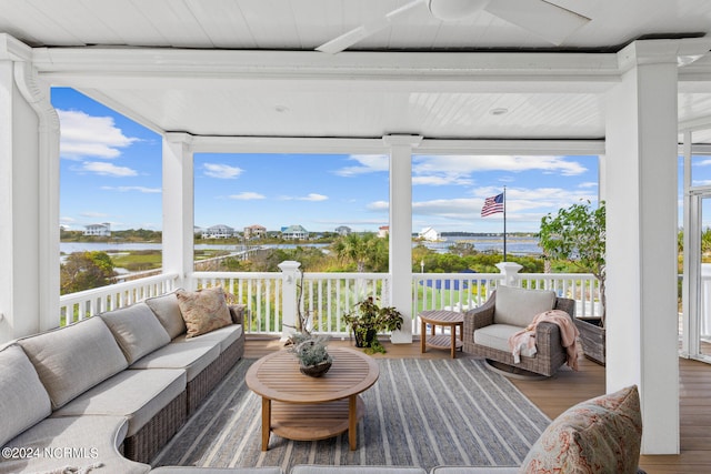 sunroom featuring a water view