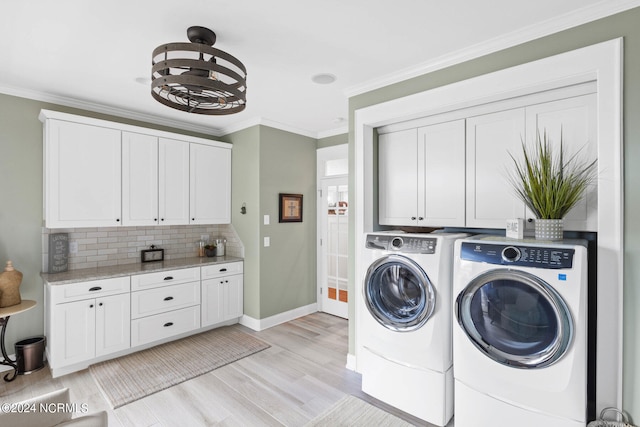 laundry room featuring cabinets, ornamental molding, independent washer and dryer, and light hardwood / wood-style flooring