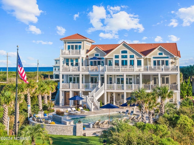 back of house featuring a balcony, a patio, and a water view