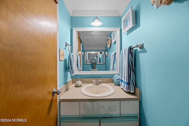 bathroom featuring vanity, crown molding, and a textured ceiling