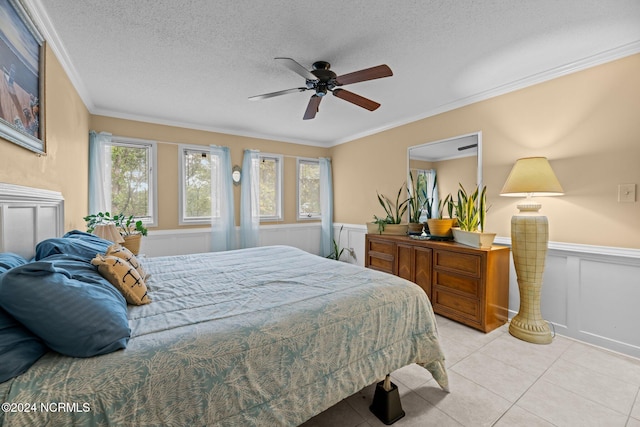 bedroom with ornamental molding, a textured ceiling, light tile patterned floors, and ceiling fan