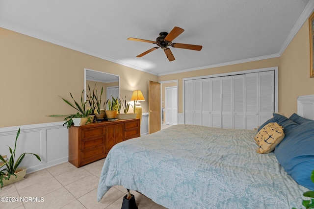 tiled bedroom featuring a closet, ceiling fan, crown molding, and a textured ceiling