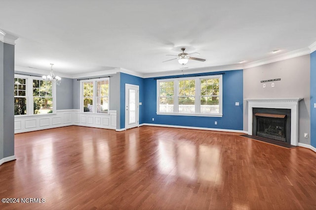 4301 Peeble Dr, Wilmington, NC 28412 - unfurnished living room featuring a fireplace with flush hearth, wood finished floors, a healthy amount of sunlight, crown molding, and ceiling fan with notable chandelier