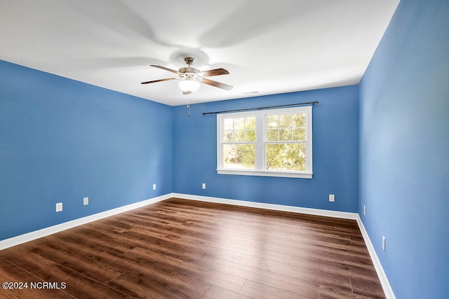 spare room featuring ceiling fan and dark wood-type flooring