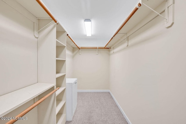 walk in closet featuring light carpet and washer and dryer