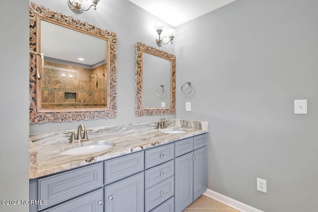 bathroom with tiled shower, vanity, and tile patterned floors