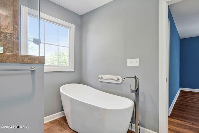 bathroom with a tub and hardwood / wood-style flooring