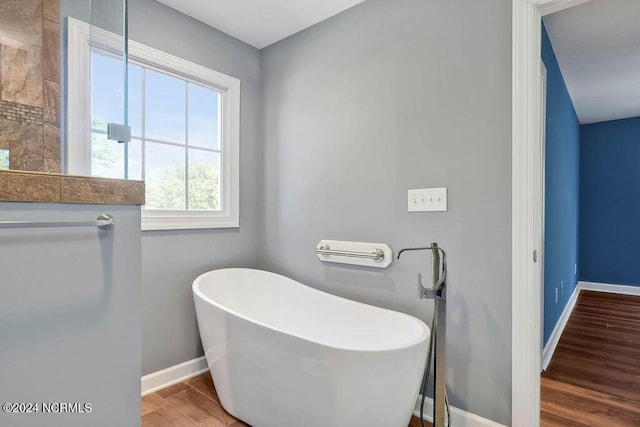 4301 Peeble Dr, Wilmington, NC 28412 - bathroom with a soaking tub, baseboards, and wood finished floors
