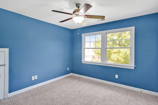 carpeted spare room with ceiling fan