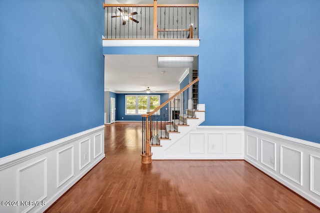 stairs featuring ceiling fan and wood-type flooring