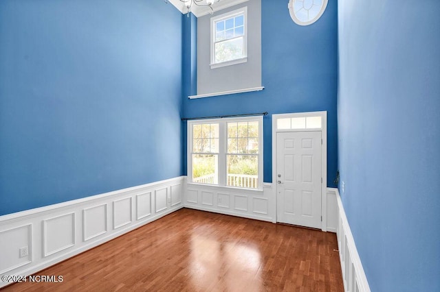 4301 Peeble Dr, Wilmington, NC 28412 - foyer entrance featuring wainscoting, wood finished floors, a notable chandelier, and a healthy amount of sunlight