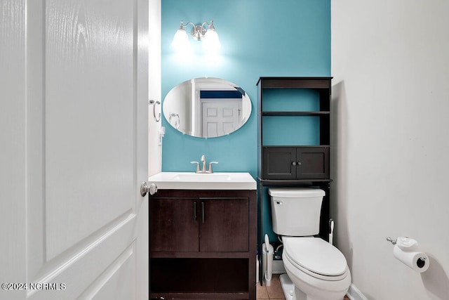 bathroom with tile patterned flooring, vanity, and toilet